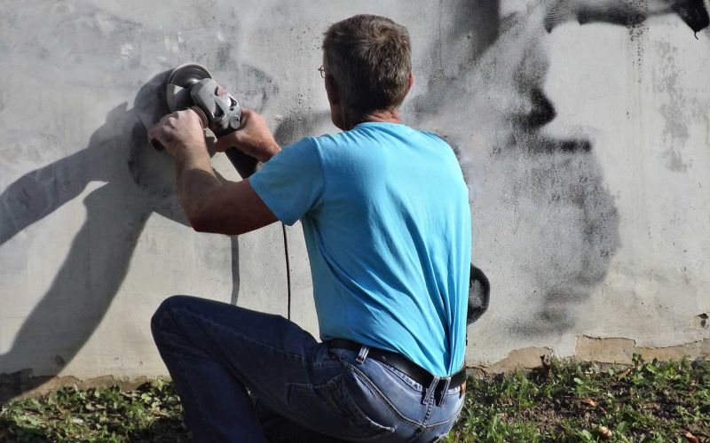 Man power washing sidewalk